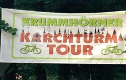 Man sieht einen Banner zur Kirchturm-Tour. Darauf zu sehen sind neben dem Schriftzug auch die Silhouetten aller Kirchtürme, die man auf der Tour besucht.